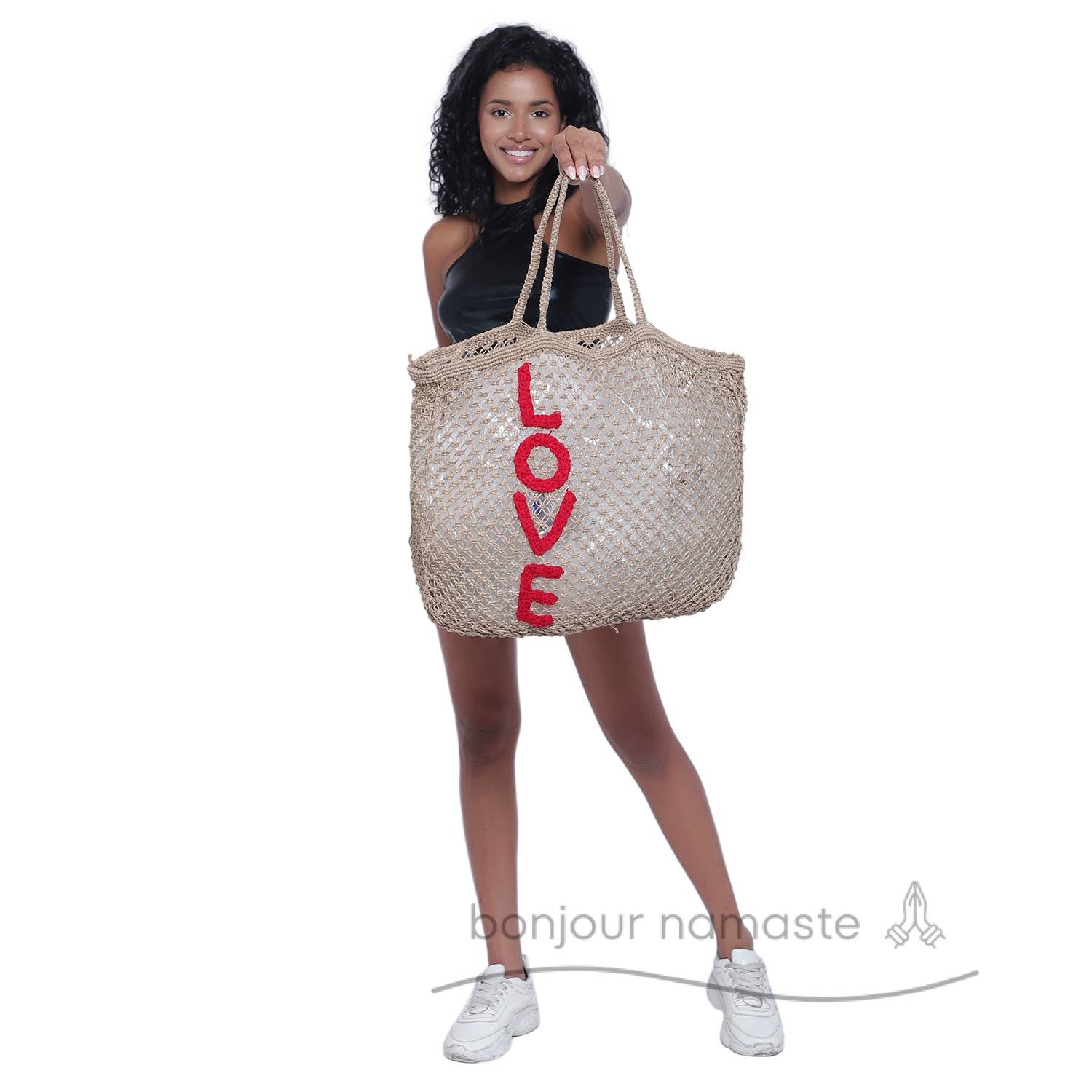 Woman holding eco-friendly LOVE jute tote with grace and style